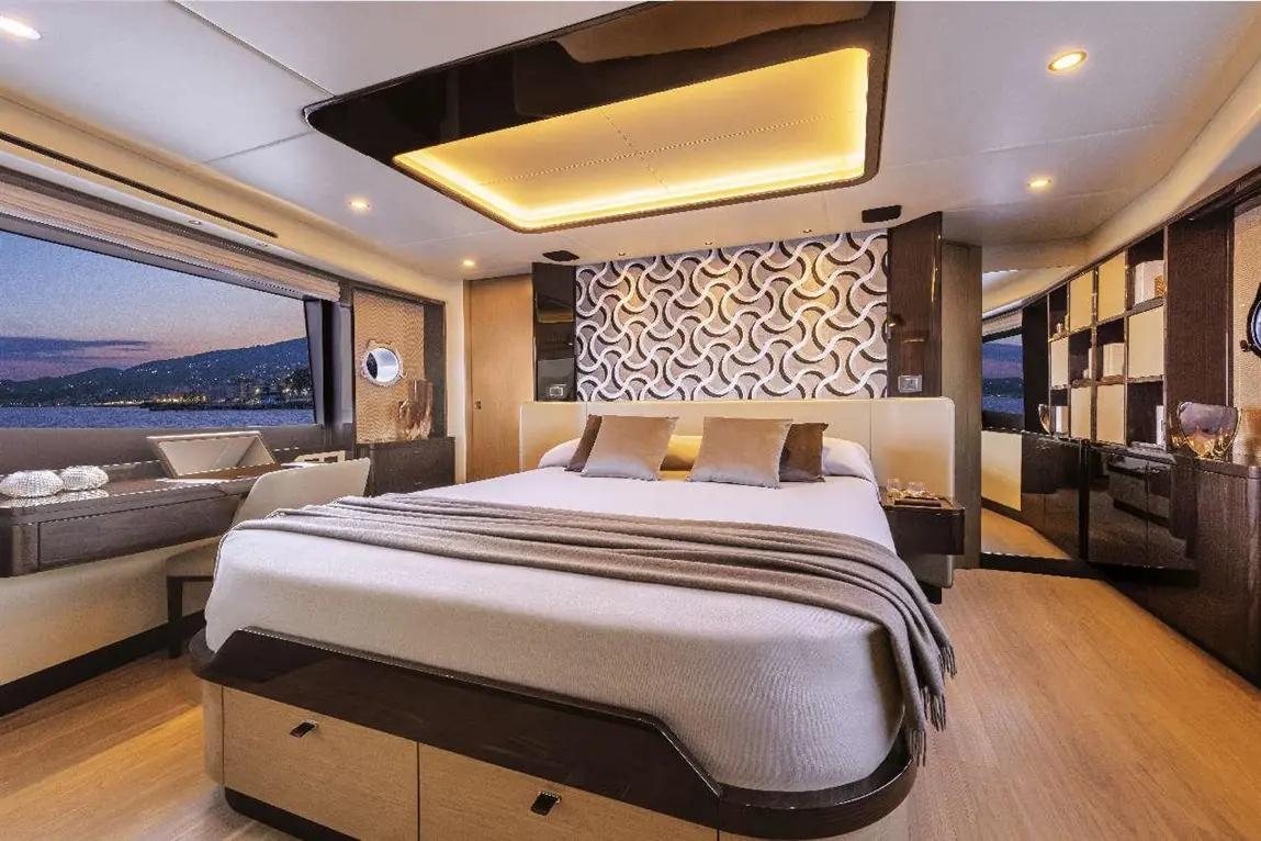 Luxury bedroom with a king-size bed, decorative wall, large window, and modern furniture, featuring a serene waterfront view.